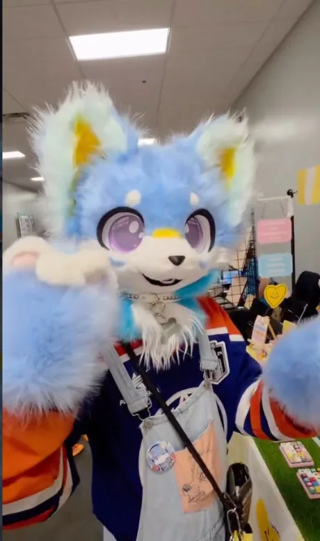 A blue and white kemono suiter waving at the camera